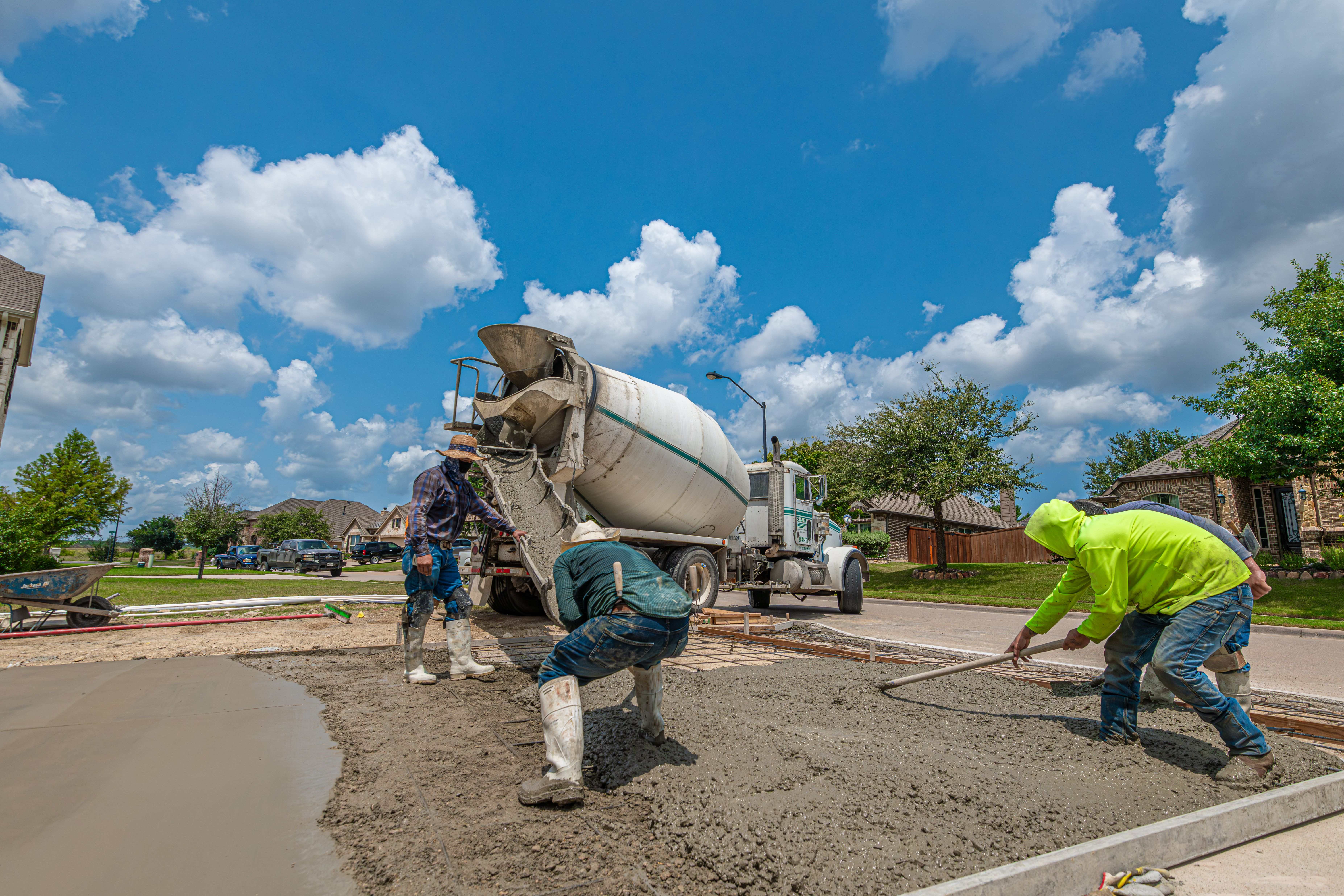 Structura Concrete crew placing and screeding a residential concrete driveway from a mixer truck